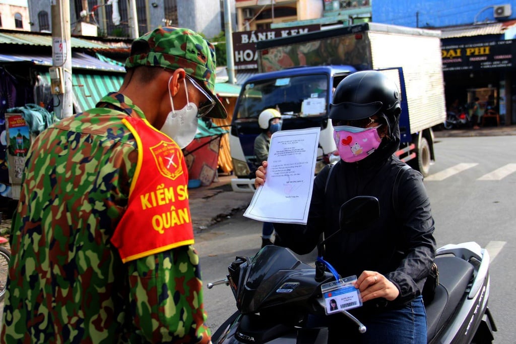 Người dân TP. Hồ Chí Minh xuất trình giấy đi đường tại chốt kiểm soát. Ảnh: VnE